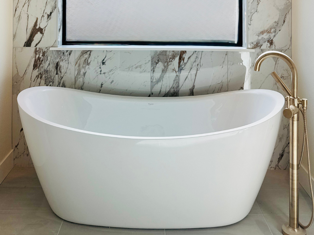 Stone wall tile in a bathroom with freestanding tub and faucet